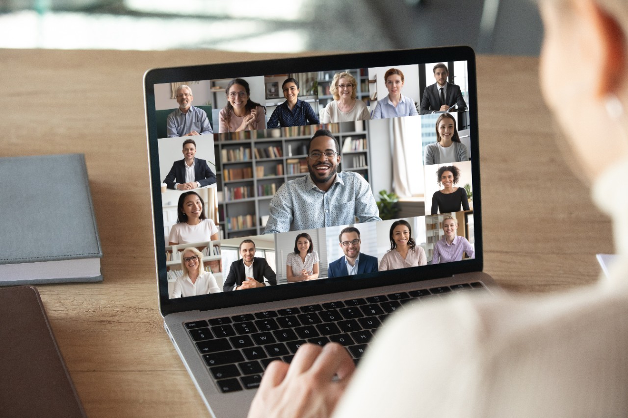 Back view of female employee speak talk on video call with diverse multiracial colleagues on online event briefing, woman worker have Webcam group conference with coworkers on modern laptop at home